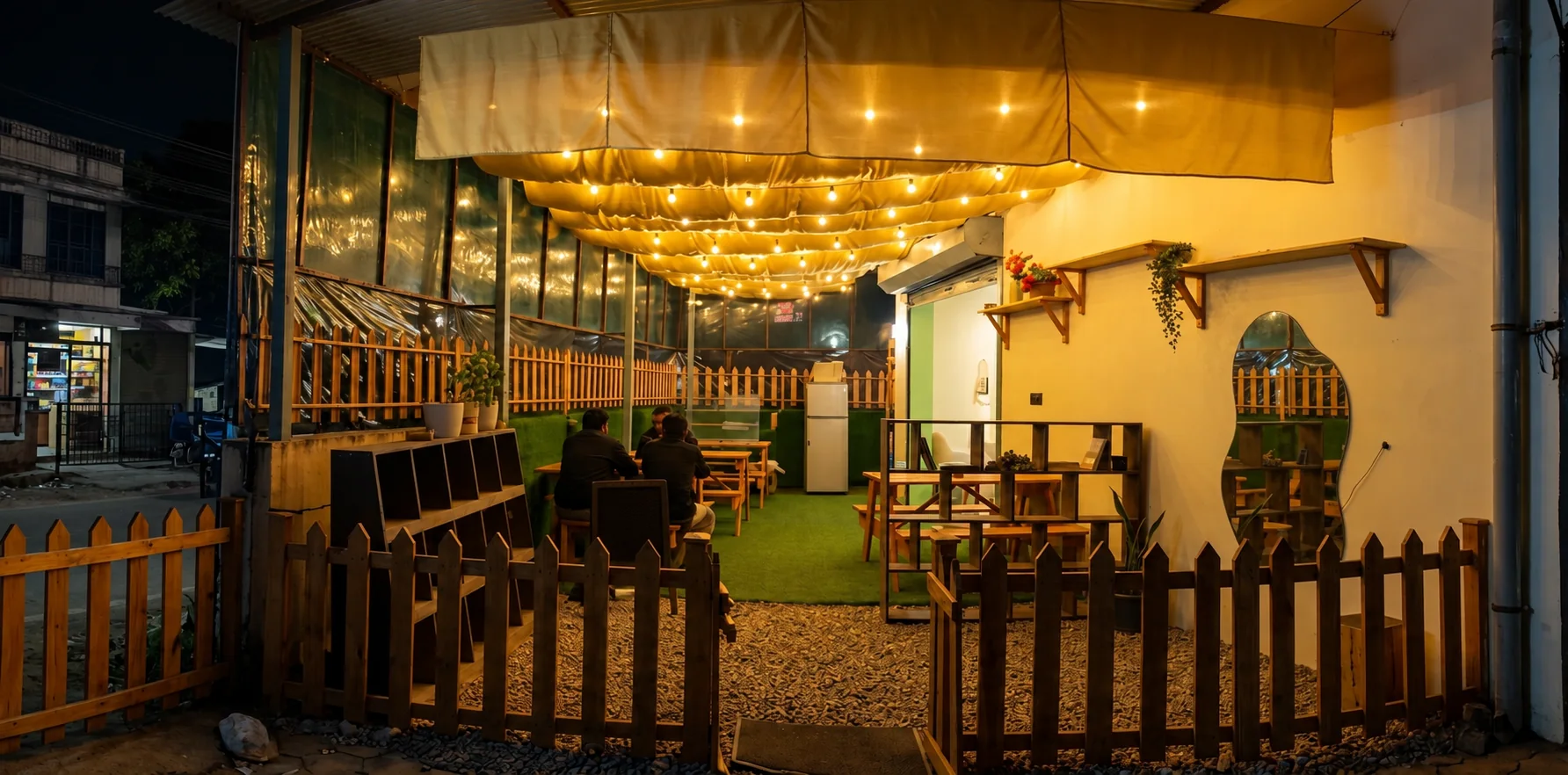 Noko's patio after dark, with string lights over wooden tables