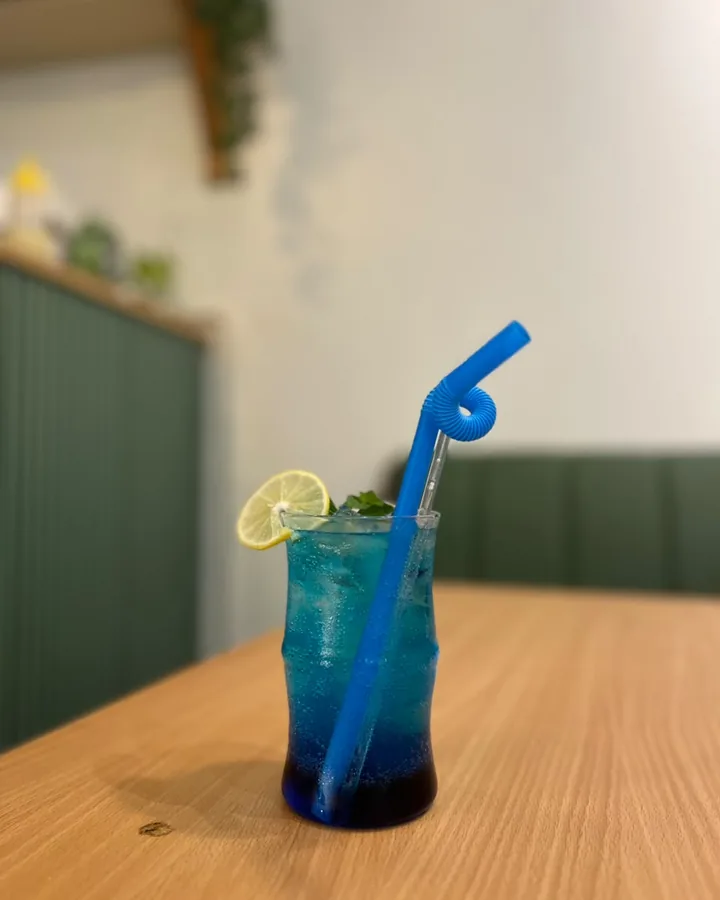A blue lime soda with a bendy straw